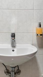 un lavabo blanco en un baño de azulejos blancos en Wohnung in Kirchditmold en Kassel