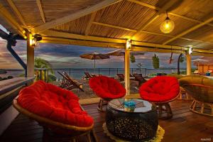 veranda con sedie, tavolo e vista sull'oceano di Le Grand Bleu ad Andilana