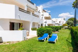 a villa with two blue chairs in the yard at Apartments Maria - Balaia 702 in Albufeira
