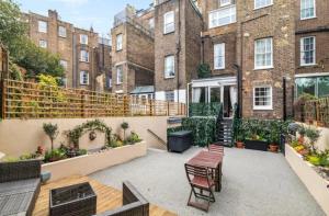 an outdoor patio with tables and chairs and buildings at Luxury 2 bed Apartment in London