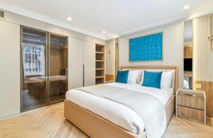 a bedroom with a large white bed with blue pillows at Luxury 2 bed Apartment in London