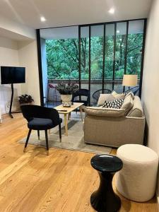 ein Wohnzimmer mit einem Sofa und einem Tisch in der Unterkunft Exquisite Inner City Modern 1 Bedroom Apt in Sydney