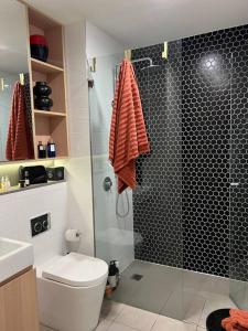 ein Bad mit einem WC und einer Glasdusche in der Unterkunft Exquisite Inner City Modern 1 Bedroom Apt in Sydney