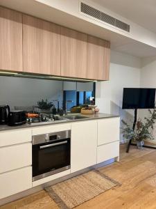 eine Küche mit einer Spüle und einem Herd Top-Backofen in der Unterkunft Exquisite Inner City Modern 1 Bedroom Apt in Sydney