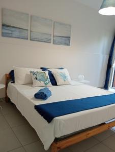 Una cama grande con almohadas azules encima. en villa Amelie, en Fondachello