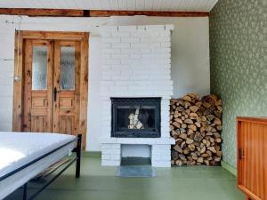a room with a fireplace and a pile of fire wood at Domek na odludziu in Sarnaki