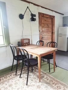 a dining room table with chairs and a refrigerator at Domek na odludziu in Sarnaki