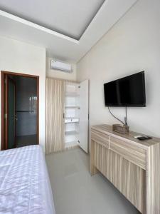 a bedroom with a bed and a flat screen tv at Akara Villa Jimbaran in Jimbaran