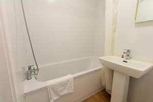uma casa de banho branca com um lavatório e uma banheira em Centrally Located 1Bed Apt in Stretford em Manchester