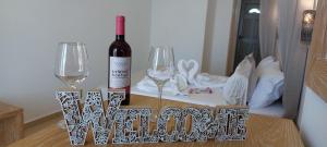 una bottiglia di vino e due bicchieri di vino su un tavolo di Selinopetra Rooms a Elafónisos