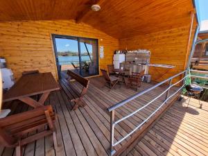 a cabin with a wooden deck with a table and chairs at Ada Bojana kucica Una in Ulcinj