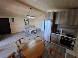 a kitchen and dining room with a table and a refrigerator at Ada Bojana kucica Una in Ulcinj