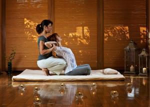 a woman sitting on a mattress holding a child at Maison Balmelle - Maison d'hôtes de Caractère in Gramat
