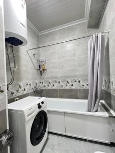 łazienka z pralką i wanną w obiekcie Квартира на Мурас Ордо w mieście Osz
