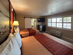 a hotel room with two beds and a television at Motel 6 Pasadena, CA Old Town Pasadena Area in Pasadena