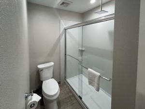 a bathroom with a toilet and a glass shower stall at Motel 6 Pasadena, CA Old Town Pasadena Area in Pasadena