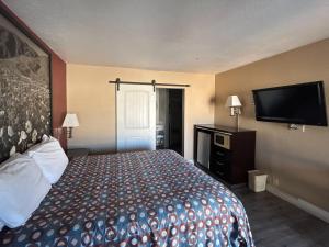 a hotel room with a bed and a flat screen tv at Motel 6 Pasadena, CA Old Town Pasadena Area in Pasadena