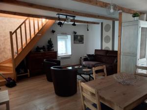 salon ze stołem i kanapą w obiekcie APPARTEMENT EN DUPLEX " LA DORDOGNE" dans maison individuelle w mieście Mont-Dore