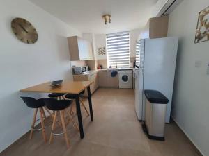 a kitchen with a table and a refrigerator at Anamor apartment 408 in Larnaca