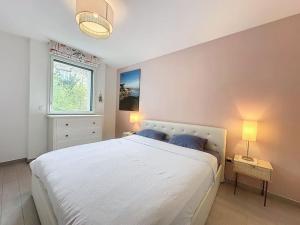 a bedroom with a large white bed and a window at Cozy apartment near Paris Disney - 6 min from train station in Villiers-sur-Marne