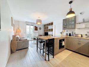 eine Küche und ein Wohnzimmer mit einem Tisch und einem Sofa in der Unterkunft Cozy apartment near Paris Disney - 6 min from train station in Villiers-sur-Marne