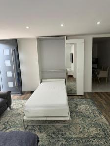białe łóżko w pokoju z lustrem w obiekcie Studio 45m2 très calme w mieście Village-Neuf