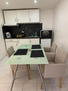 a kitchen with a table with chairs and a microwave at Studio 45m2 très calme in Village-Neuf