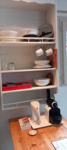 uma cozinha com pratos e utensílios nas prateleiras em Villa Rose em Escolives-Sainte-Camille