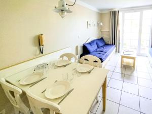 salon ze stołem, krzesłami i kanapą w obiekcie Maison au cœur d'un village vacances proche golf port et plage - 5 pers w mieście Saint-Hilaire-de-Talmont