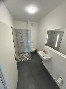 y baño con ducha y lavamanos. en Modern eingerichtetes Apartment zum entspannen und wohlfühlen, en Oldenburg