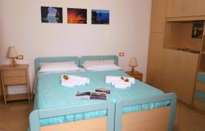 a blue bed with towels and books on it at LE CASE DI CICCIO - Casa Girasole in Pantelleria