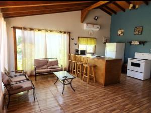 a living room with a kitchen and a table at Corrales House in Tela