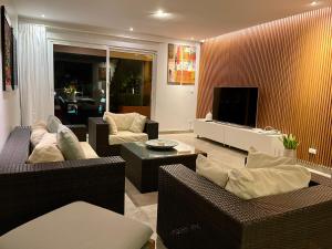 a living room with couches and a flat screen tv at Eagle Vacation Home in Palm-Eagle Beach
