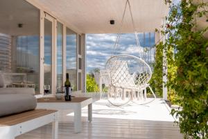 - une terrasse couverte avec une chaise blanche et une balançoire dans l'établissement Buqez 58 - Drage villas, à Drage