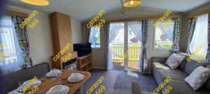 a living room with a couch and a table at Sean's 569 cader court 045 in Talybont