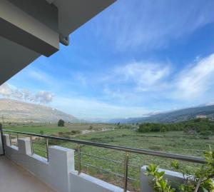 a balcony with a view of a field and mountains at Hotel Selfo in Gjirokastër