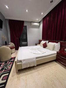 吉諾卡斯特的住宿－Hotel Selfo，一间卧室配有一张带红色窗帘的大床