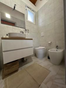 uma casa de banho com um lavatório e um WC em B&B Spiaggia Le Dune em Margherita di Savoia