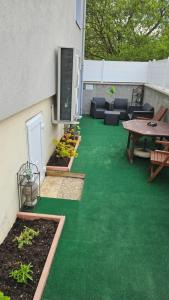 patio z zieloną trawą, stołem i krzesłami w obiekcie Chez Marie et Daniel w mieście Vrigne-aux-Bois