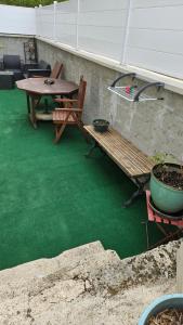 drewniana ławka i stół na patio w obiekcie Chez Marie et Daniel w mieście Vrigne-aux-Bois