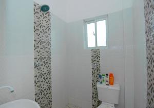 a bathroom with a toilet and a window at Beau Fahy Nyali studio apartment in Mombasa