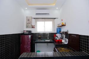 a small kitchen with black tiled counters and a sink at Beau Fahy Nyali studio apartment in Mombasa