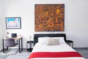 a bedroom with a bed and a painting on the wall at Beau Fahy Nyali studio apartment in Mombasa