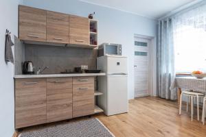 a kitchen with wooden cabinets and a white refrigerator at Noclegi u Eweliny in Zator +13 photos