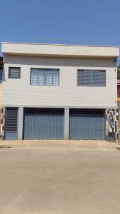 a white building with four garage doors on a street at Casa Bela Vista da Serra da canastra in São Roque de Minas