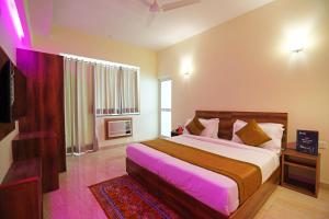a bedroom with a large bed and a television at Hotel Franklein Suites At Delhi Airport in New Delhi