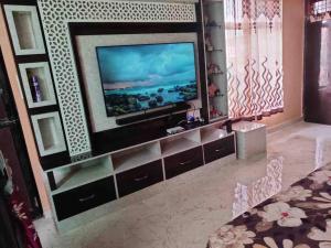 uma sala de estar com televisão num centro de entretenimento em Your Own Sweet Nest in Gwalior with comfort em Gwalior
