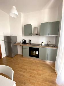 a kitchen with stainless steel appliances and a wooden floor at [Elce-Perugia] Brightest Condo 1 Km From The CityCenter in Perugia