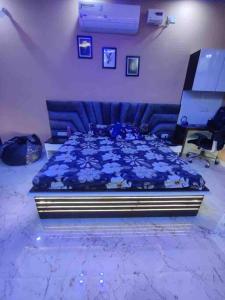 sypialnia z niebieskim łóżkiem z kwiatami w obiekcie Your Own Sweet Nest in Gwalior with comfort w mieście Gwalijar