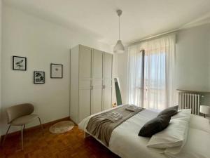 a bedroom with a bed and a chair and a window at [Elce-Perugia] Brightest Condo 1 Km From The CityCenter in Perugia